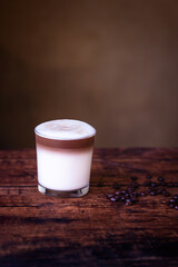 Coffee cafe latte macchiato in a glass on a wooden background.