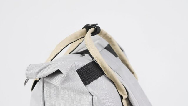 Closeup gray backpack bag rotates on white background, 4K