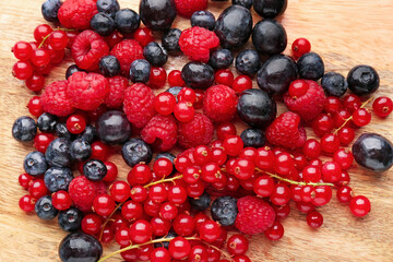 Wooden board with ripe berries, closeup