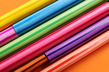 Set of colorful pencils on orange background, closeup