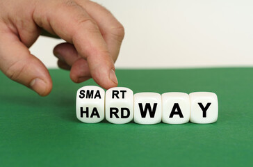 On a green surface are white cubes with the inscription - SMART WAY or HARD WAY