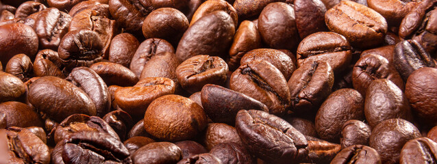 Coffee break background. Hot coffee in cup and roasted coffee beans on a wooden table. Copy space	