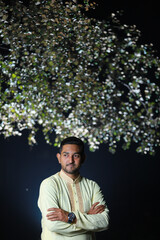 South asian young nice looking groom wearing a traditional wedding dress doing outdoor fashion photography at night 