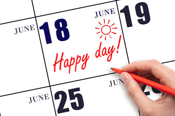 Hand writing the text HAPPY DAY and drawing the sun on the calendar date June 18