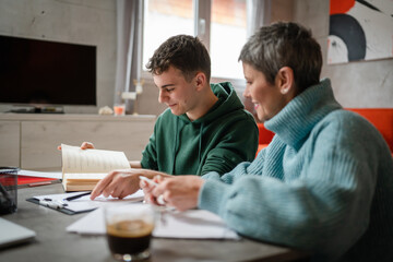 One student teenage caucasian man study learn with help of his tutor professor or mother senior...