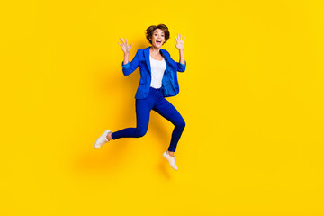 Fototapeta na wymiar Full length photo of pretty impressed lady dressed blue blazer jumping high rising hands arms isolated yellow color background
