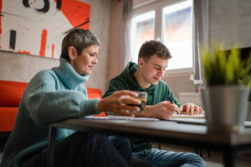 One student teenage caucasian man study learn with help of his tutor professor or mother senior...