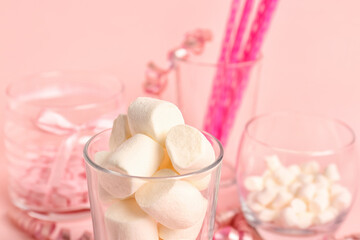 Glass of tasty marshmallows on pink background, closeup