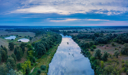 Beautiful Ukrainian nature background. Drone view on riverbank of the Seym river and amazing cloudscape over it. Summertime.