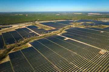 Aerial view of large sustainable electrical power plant with rows of solar photovoltaic panels for producing clean electric energy. Concept of renewable electricity with zero emission