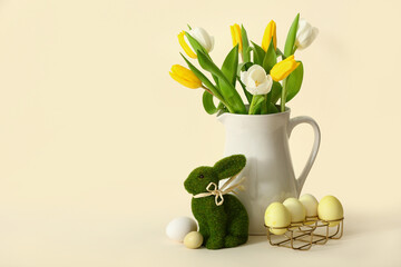 Jug with beautiful tulip flowers, painted Easter eggs and bunny on color background