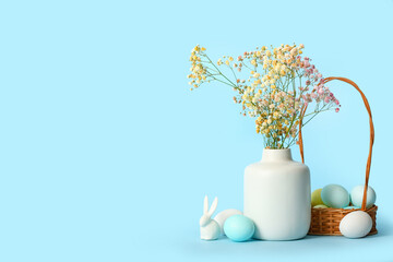 Vase with gypsophila flowers, basket of Easter eggs and bunny on color background