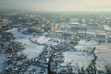 Aerial view of residential houses with snow covered roofops in suburban rural town area in winter