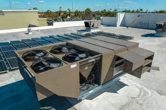 External Unit Of Commercial Air Conditioning And Ventilation System Installed On Industrial Building Roof. Exhaust Vent On Flat Factory Rooftop