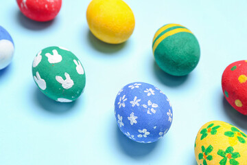 Painted Easter eggs on light blue background, closeup