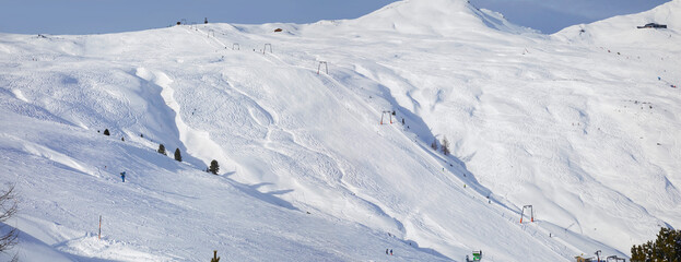Fototapeta na wymiar Schönes Winterpanorama im Skigebiet Wildkogel bei Bramberg in Österreich, mit Skifahrer im Tiefschnee.