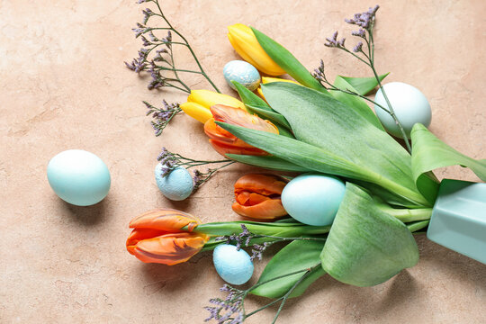 Composition with beautiful flowers and painted Easter eggs on color background, closeup