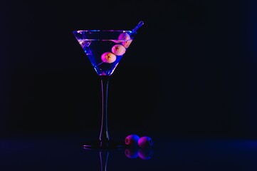 Drink martini. Martini with olives on a black table. Free space for text.