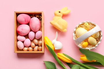 Composition with Easter eggs, bunnies and tulip flowers on pink background