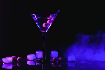 Martini cocktail drink splash with ice cubes in neon iridescent pink and blue colors. Minimal night party life concept.