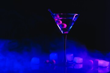 Martini cocktail drink splash with ice cubes in neon iridescent pink and blue colors. Minimal night party life concept.