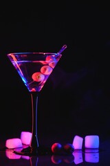 Martini cocktail drink splash with ice cubes in neon iridescent pink and blue colors. Minimal night party life concept.