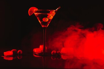 Martini glass and olives on a black background with neon lights