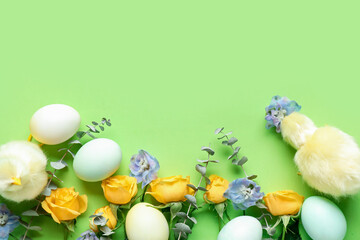 Composition with painted Easter eggs, beautiful flowers and toy chicks on green background