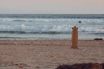 A longboard at sunset on a california beach. horizontal