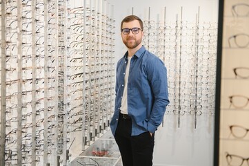Fototapeta na wymiar male client chooing new eyeglasses frame for his new eyeglasses in optical store