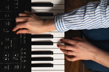 Fototapeta na wymiar Woman's hands on synthesizer keys