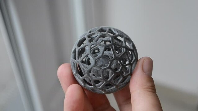 Person holding in hand model printed on a 3D printer from polyamide powder using technology MJF close-up. Three-dimensional object gray color printed on a 3D printer. Modern new innovation technology