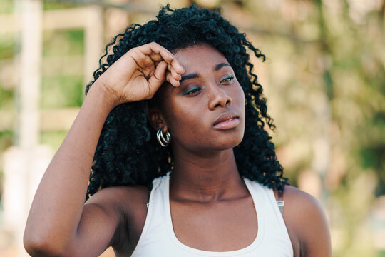 bella mujer afroamericana joven con afro con su rostro cansado despu&eacute;s de hacer deportes por la ciudad.