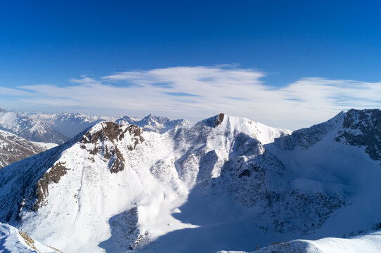 Alps in the background, the towering mountains are covered with fresh white snow against turquoise sky © rossano