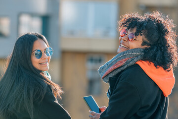 two girls friends in the street with mobile phone