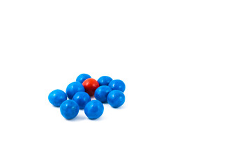 Group of blue colored candy and one red candy on a white background