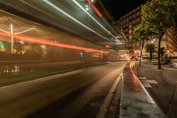 trace of the lights of a bus passing through a square
