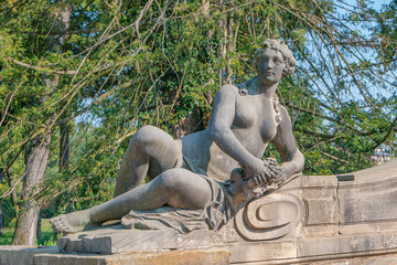 Ancient decayed statue of a sensual bathing Renaissance Era woman in the central city park of...
