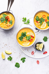 Light orange veggie curry with chickpeas, chili peppers, coriander leaves and cumin seeds on a...