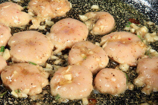 slices of fried testicles are fried on a pan with onions and spices