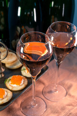 Tasting of rose brut Champagne sparkling wine with red caviar in cellars of gran cru wine house in Epernay, wine tour in Champagne, France