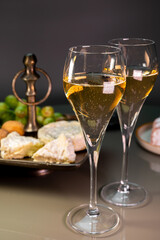 Glasses of sparkling white wine champagne or cava with bubbles and french soft cheese on background