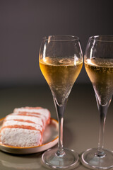 Glasses of sparkling white wine champagne or cava with bubbles and sweet dessert Reims rose biscuits on background