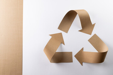 Close up of recycling symbol of paper arrows and carton on white background with copy space