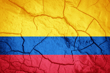 Flag of Columbia. Colombian  symbol. Flag on the background of dry cracked earth. Colombian flag with drought concept