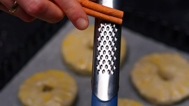 cinnamon is sprinkled with a grater on a baking sheet with cookies. High quality 4k footage