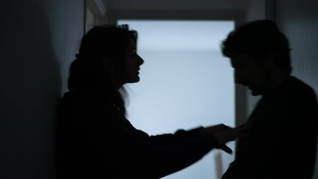 Young parents Arguing and Fighting. Domestic Violence and Emotional abuse Scene. Stressed man and aggressive Man yelling at wife at Dark Hallway of Apartment. Making peace with child