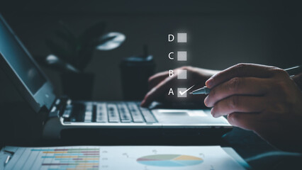 businessman using laptop take an assessment, questionnaire, evaluation, online.  Choosing the right answer in the exam. analyzing business and investment.