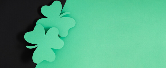 Naklejka na ściany i meble Patrick's Day composition. Holiday decoration for St. Patricks day, clover leaf on black and green background. Flat lay, top view, copy space 