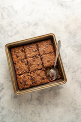 top view, vegan brownies with chocolate chips and rolled oats in square baking tray.